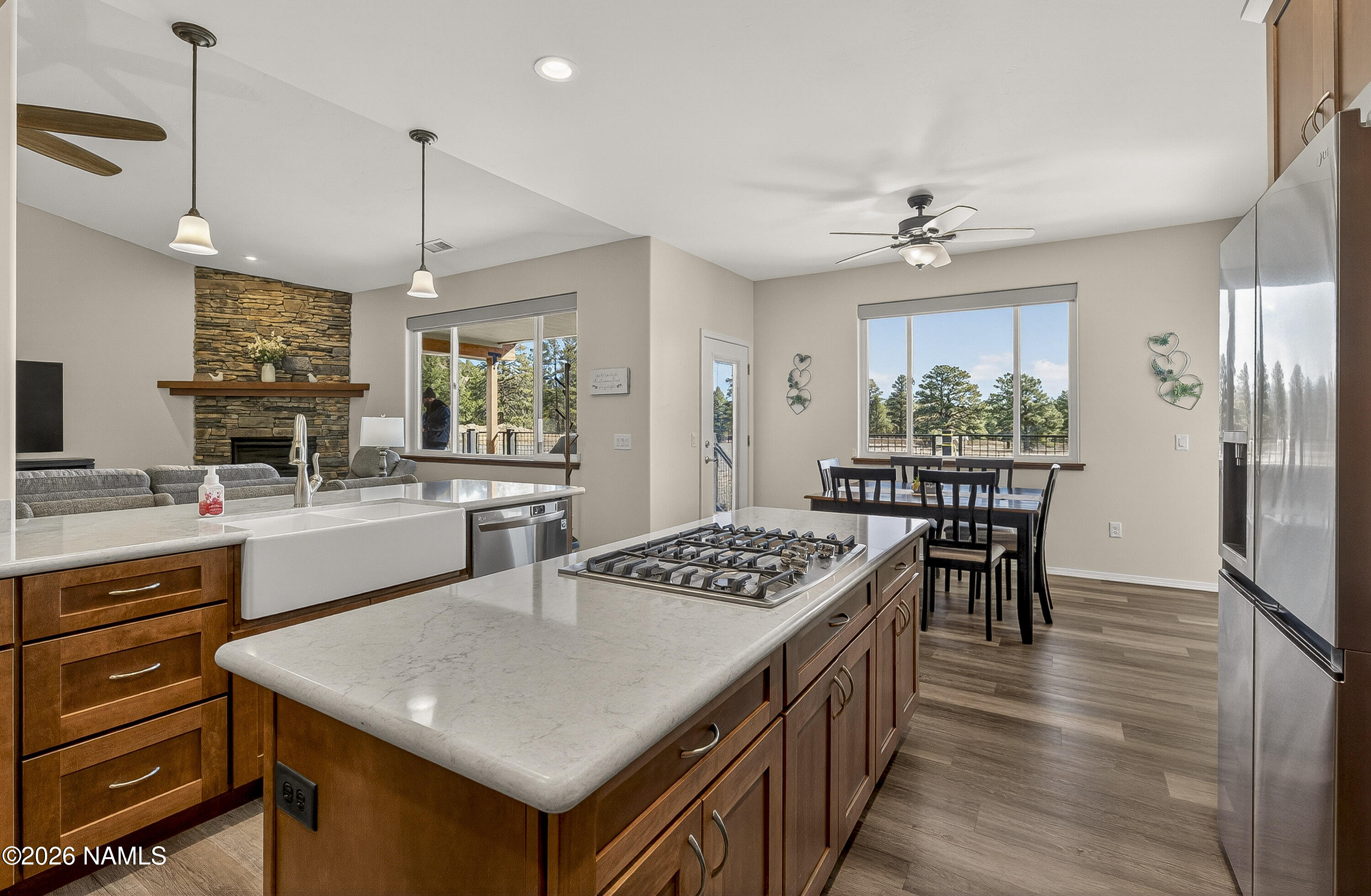 6560 Johnson Ranch Road Flagstaff, AZ 86004 - Photo 13 of 57 a kitchen with stainless steel appliances a kitchen island hardwood floor sink stove dining table and chairs