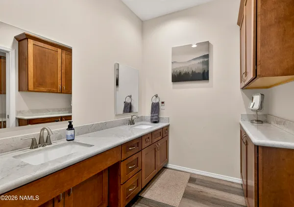 a bathroom with a granite countertop double vanity sink and mirror