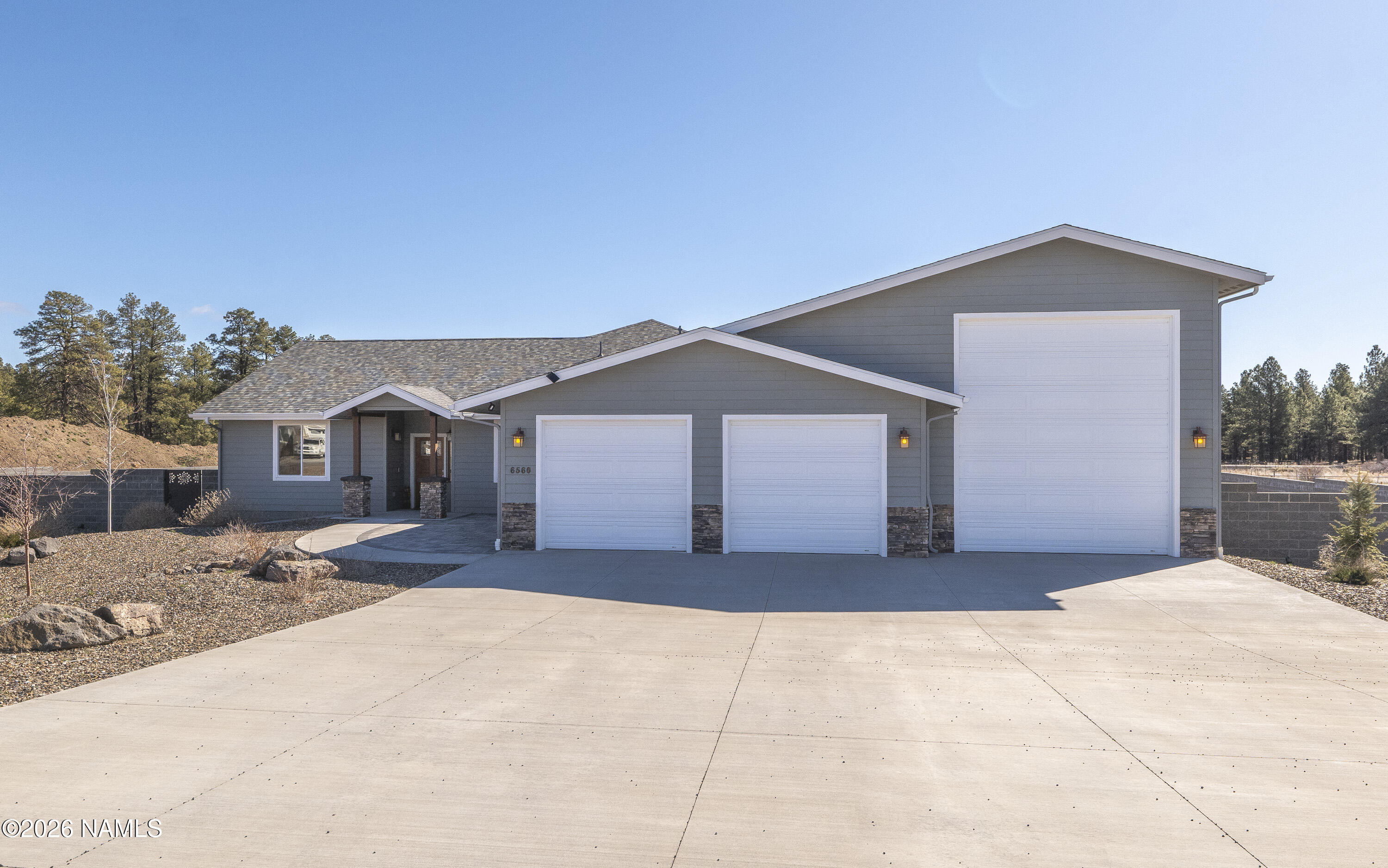 6560 Johnson Ranch Road Flagstaff, AZ 86004 - Photo 44 of 57 a front view of a house with a yard and garage