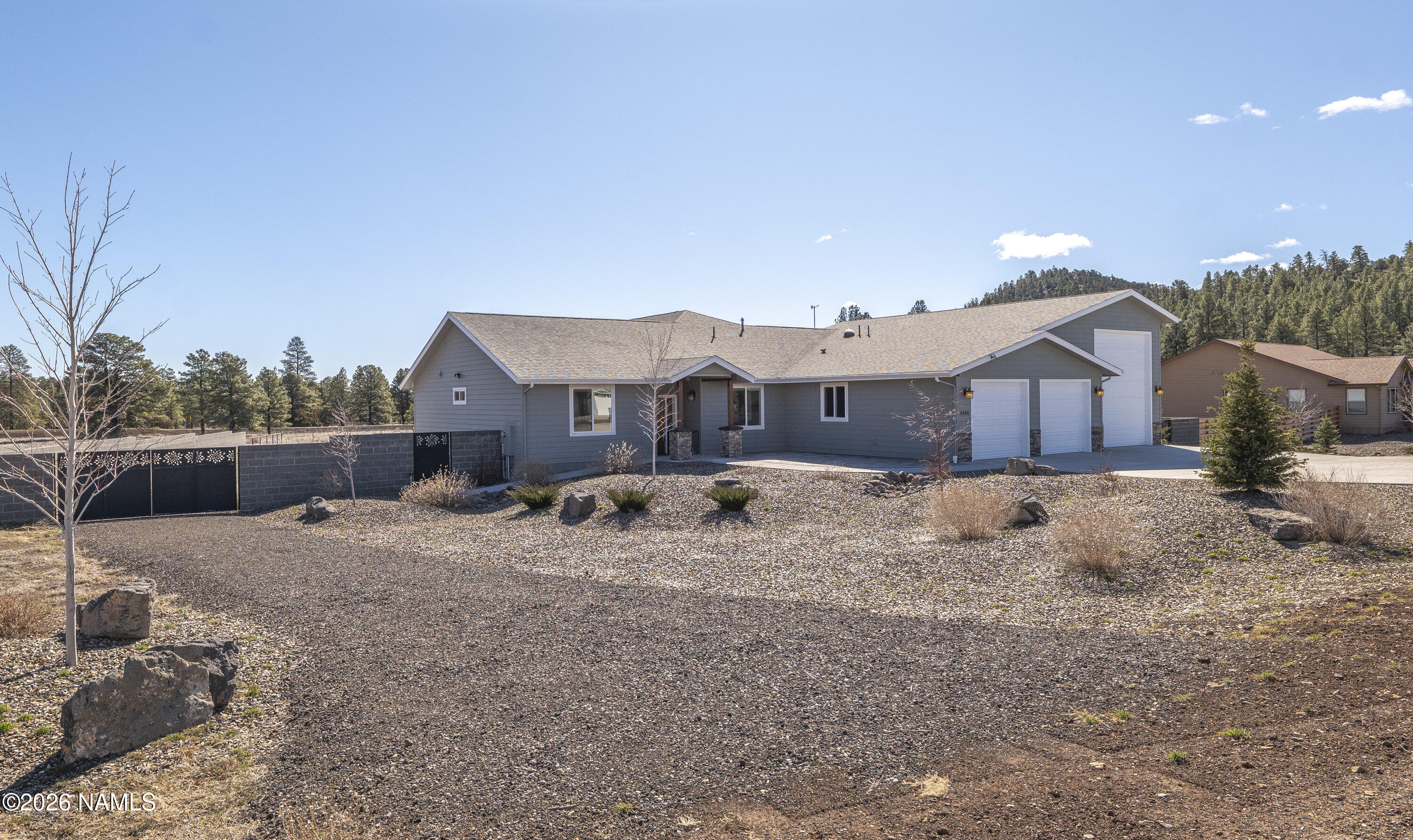 6560 Johnson Ranch Road Flagstaff, AZ 86004 - Photo 45 of 57 a front view of a house with a dirt yard and a large tree
