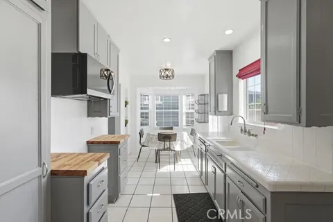 a dining hall with stainless steel appliances kitchen island granite countertop a dining table and chairs