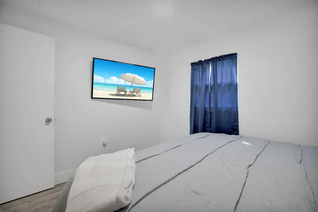 a bedroom with a large bed and wooden floor