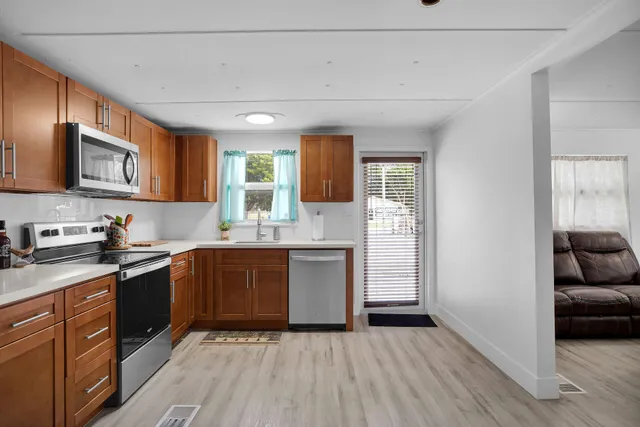 a kitchen with granite countertop stainless steel appliances a refrigerator a sink and a stove