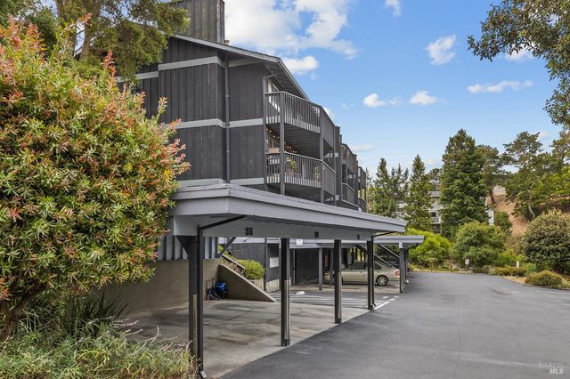 a roof deck with table and chairs under an umbrella