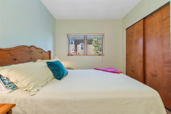a bedroom with a bed and painting on the wall