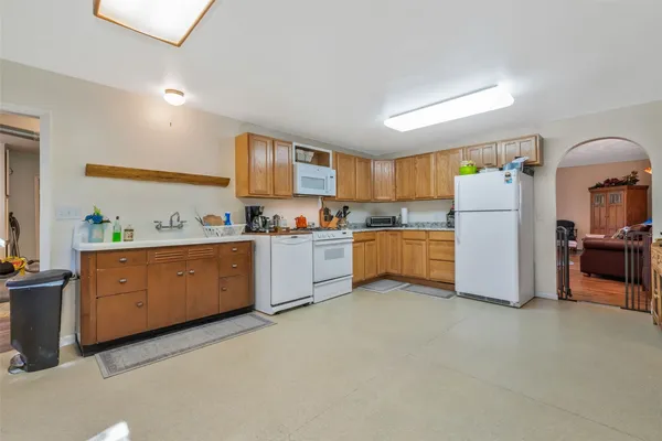 a kitchen with white cabinets and white appliances