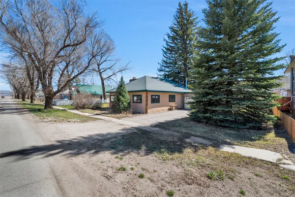 a front view of a house with a yard and trees