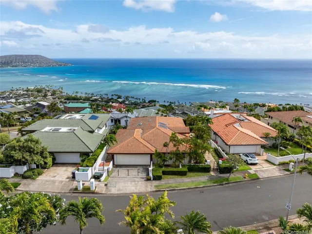 an aerial view of residential houses with outdoor space and ocean view