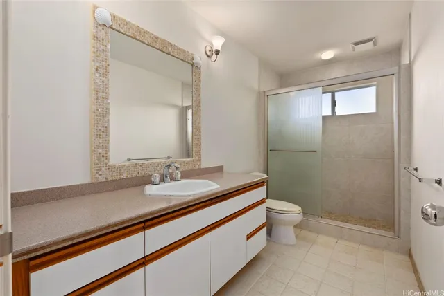 a bathroom with a sink a toilet a mirror and shower