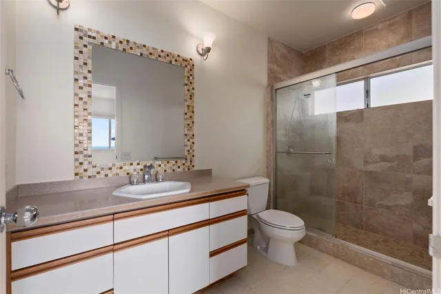 a bathroom with a granite countertop sink a toilet and shower