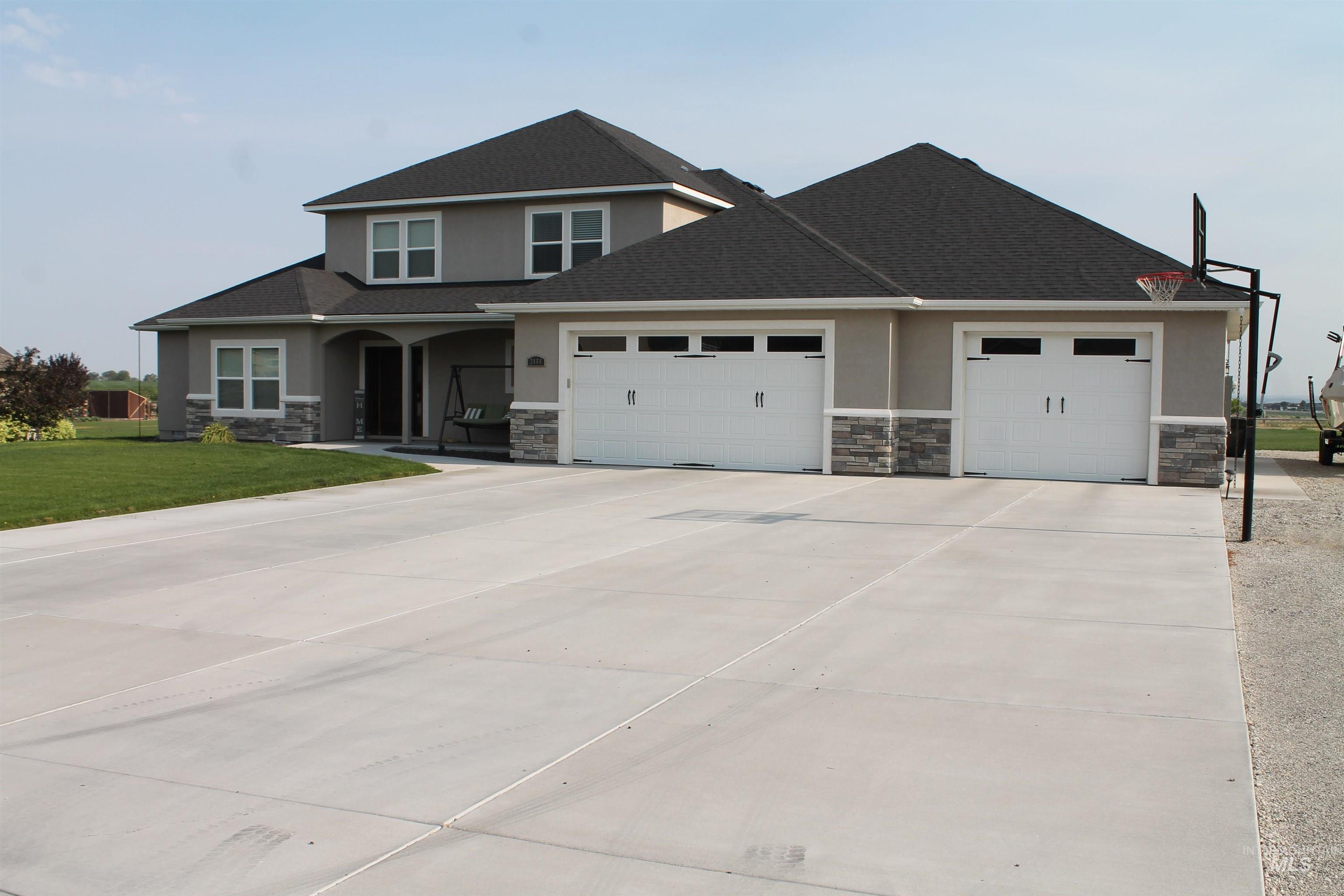 View of front of house featuring stucco, stone, and an attached garage.
