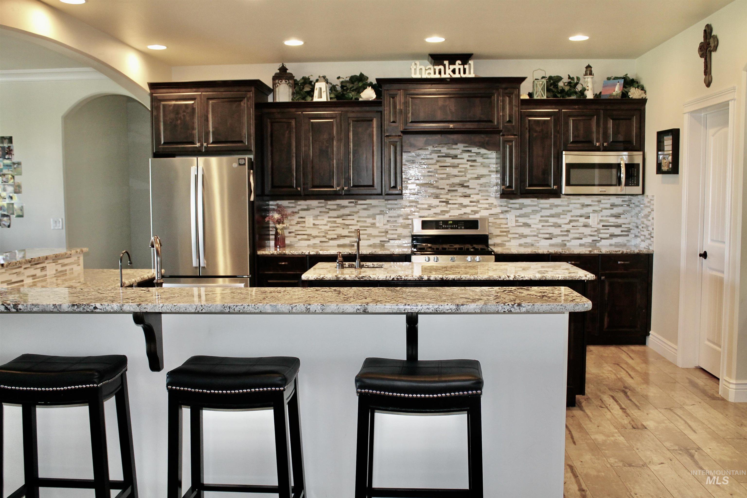 2464 Windmill Drive Twin Falls, ID 83301 - Photo 10 of 47 Kitchen featuring stainless steel appliances, breakfast bar, recessed lighting.