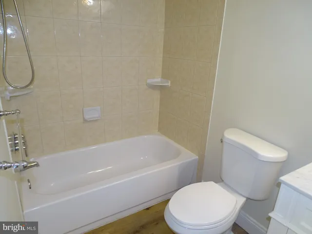 a white toilet and tub sitting next to a bathroom sink