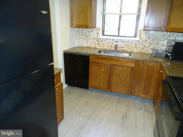 a kitchen with a sink a stove top oven and a refrigerator