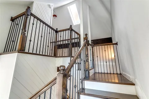 a view of staircase with railing and white walls