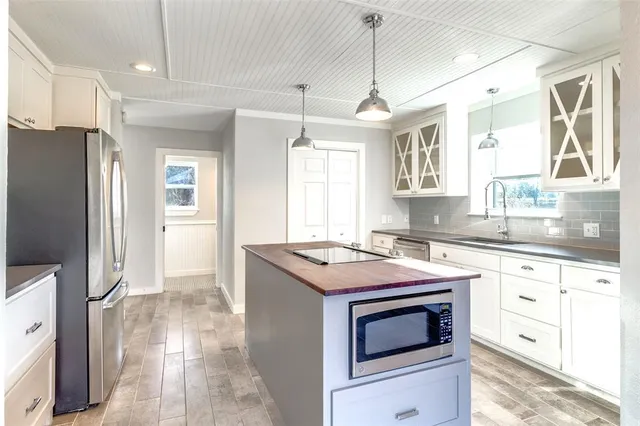 a kitchen with granite countertop a stove and a wooden floor