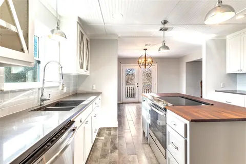 a kitchen with granite countertop a sink stove and cabinets