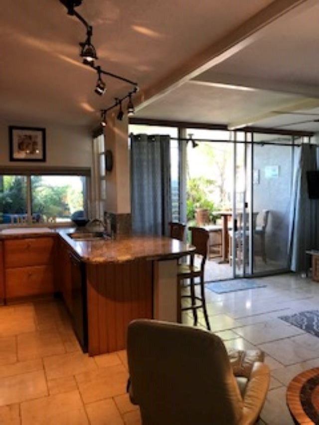 2037 South Kihei Road, Unit 1 Kihei, HI 96753 - Photo 13 of 16 a kitchen with stainless steel appliances granite countertop a table chairs and a refrigerator