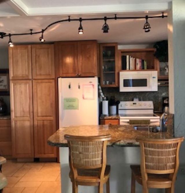 2037 South Kihei Road, Unit 1 Kihei, HI 96753 - Photo 5 of 16 a kitchen with stainless steel appliances granite countertop a stove and a refrigerator