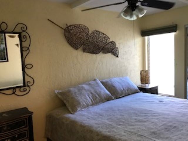 2037 South Kihei Road, Unit 1 Kihei, HI 96753 - Photo 10 of 16 a bedroom with a bed and a chandelier