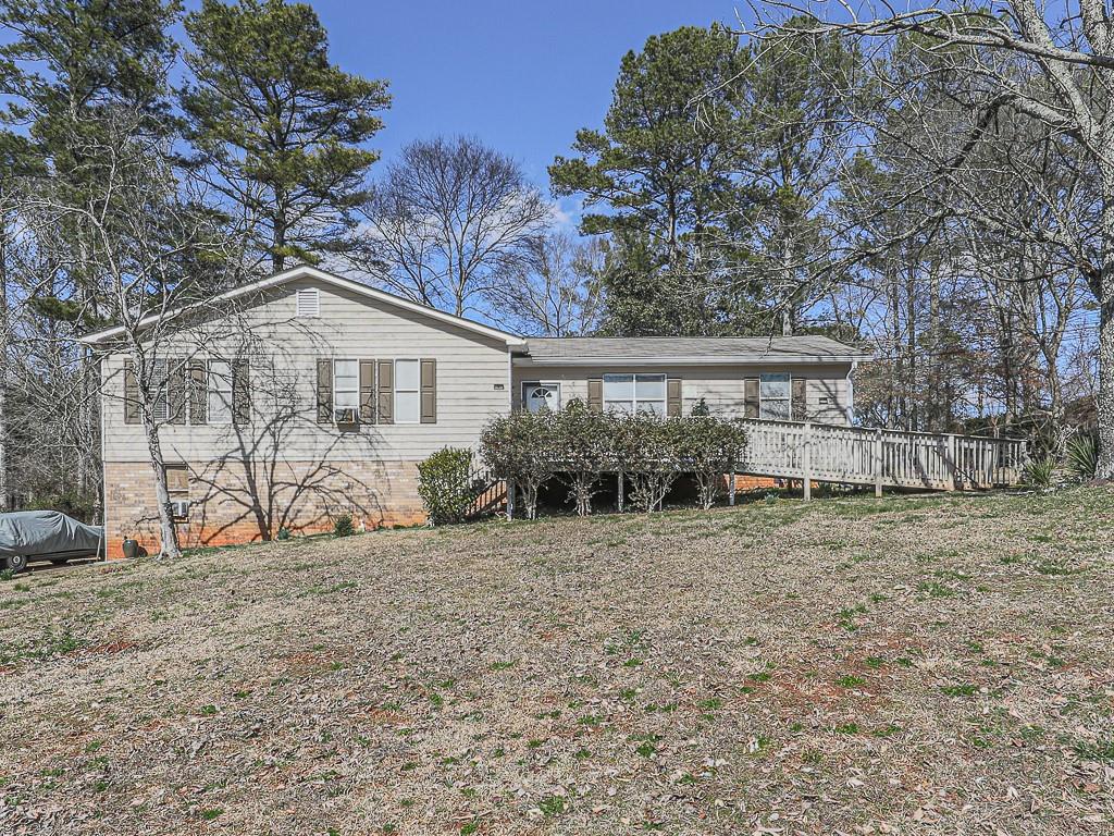 a view of a house with a yard and sitting area