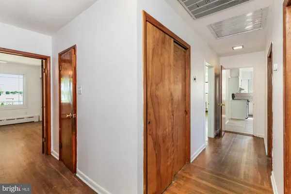 a view of a hallway with bathroom and wooden floor