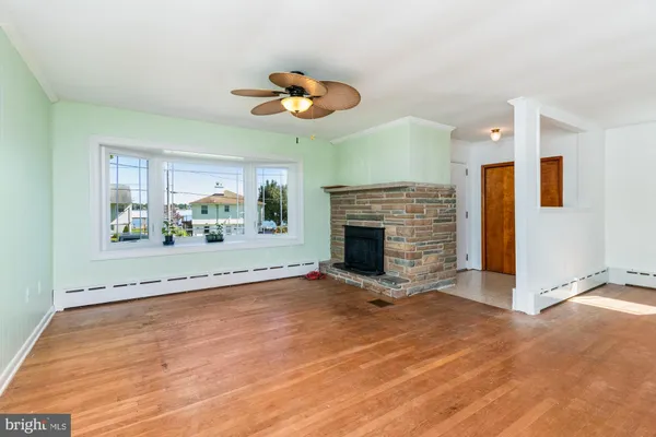 an empty room with windows and fireplace