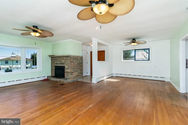 an empty room with wooden floor a fireplace