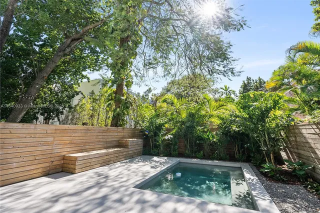a view of a yard with plants and trees