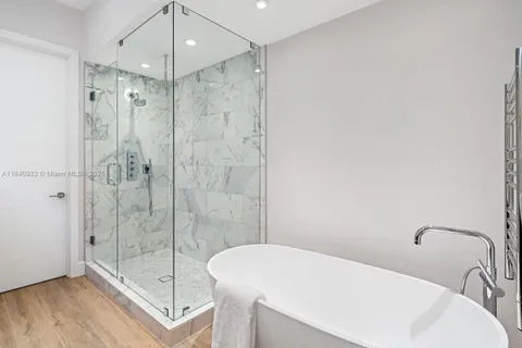 a bathroom with a shower a mirror and a sink