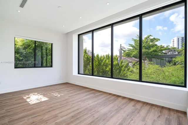 a view of empty room with wooden floor and windows