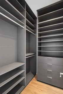 a view of walk in closet with empty racks