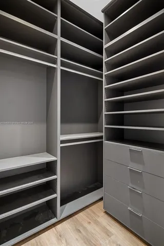 a view of walk in closet with empty racks