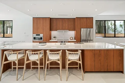 a kitchen with a dining table chairs and window