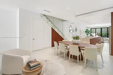 a dining room with furniture and a potted plant