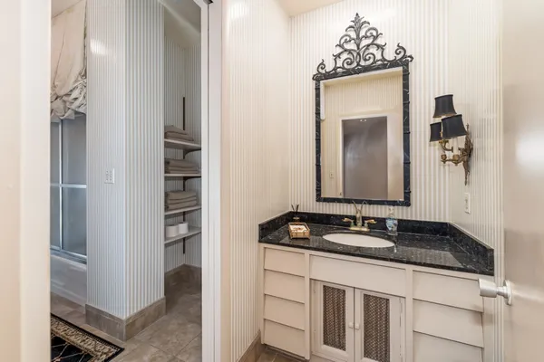a bathroom with a granite countertop sink and a mirror