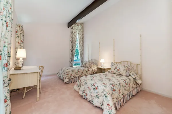 a bed sitting in a bedroom next to a window