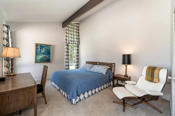 a bedroom with a bed chair and window