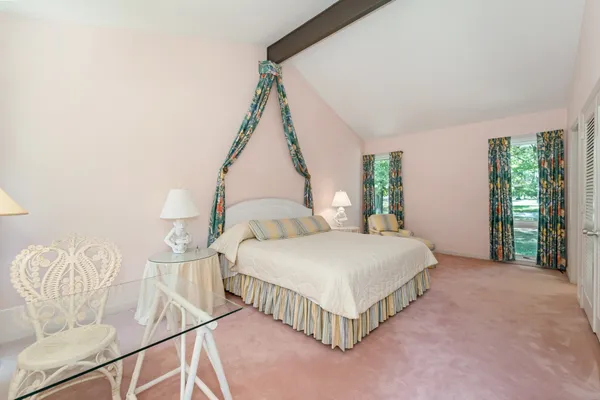 a bedroom with a bed table and window