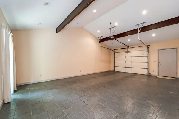 an empty room with a ceiling fan and window
