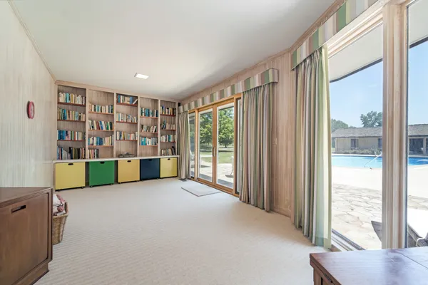 a view of an empty room with window and cabinet
