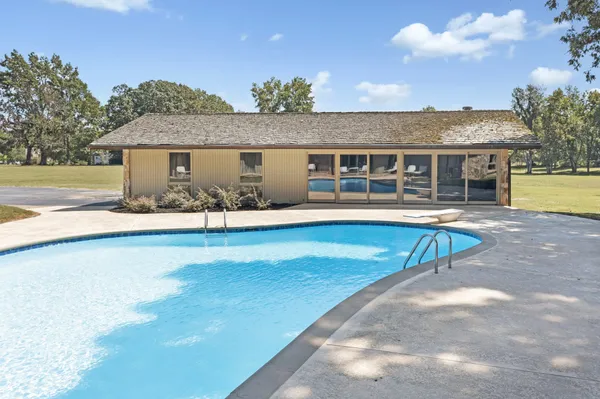 a view of a house with pool and chairs