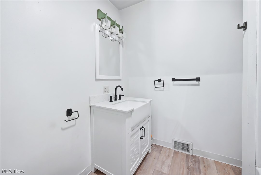 6667 Chestnut-Ridge Road Hubbard, OH 44425 - Photo 24 of 35 White shaker-style vanity with a farmhouse sink and black hardware