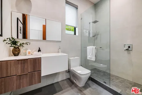 a spacious bedroom with a large bed and a flat tv screen