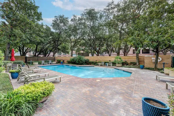 a view of backyard with swimming pool and seating space