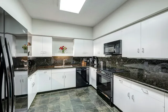a kitchen with a sink cabinets and stainless steel appliances
