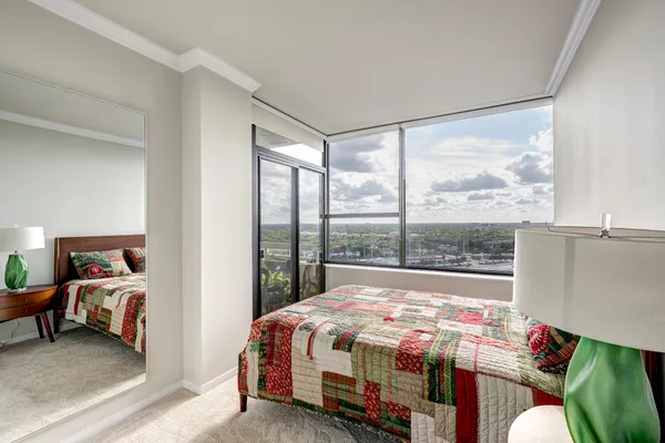 a bedroom with a bed and a large window