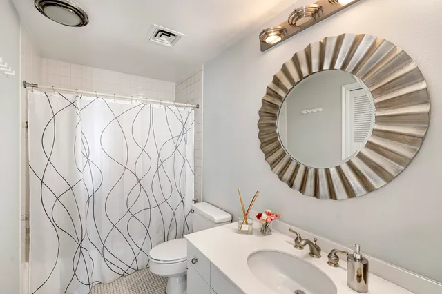 a bathroom with a sink a mirror and a toilet