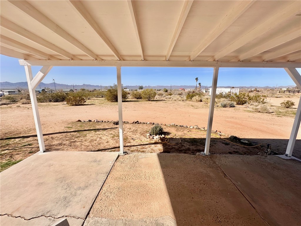 3309 Bacobi Road Golden Valley, AZ 86413 - Photo 8 of 31 View of patio featuring view of desert landscape, a mountain view, and a view of countryside