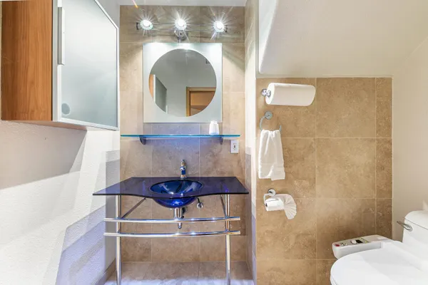 a bathroom with a granite countertop sink a toilet and shower